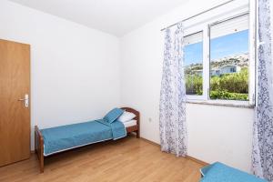 a bedroom with a bed and a window at Vila Murvica in Pag