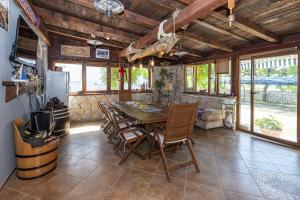 a dining room with a wooden table and chairs at Vila Murvica in Pag