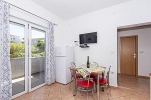 a dining room with a table and chairs and a window at Vila Murvica in Pag
