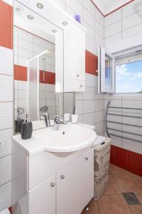 a bathroom with a white sink and a mirror at Vila Murvica in Pag +73 photos