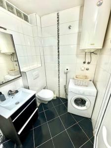 a bathroom with a toilet a sink and a washing machine at Apartman Čaršija in Novi Pazar +7 photos