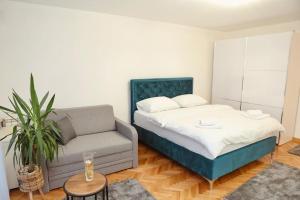 a bedroom with a bed and a couch and a chair at Apartman Čaršija in Novi Pazar