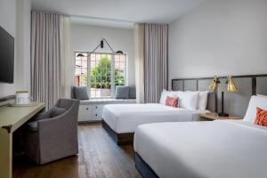 a hotel room with two beds and a window at The Alida, Savannah, a Tribute Portfolio Hotel in Savannah