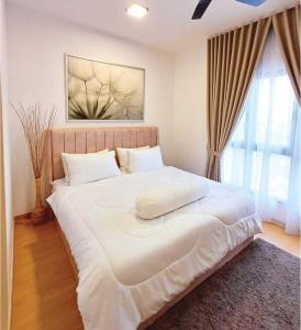 バンティングにあるMayabay Residence Gamuda Cove - LabuhSenja Homestayの窓付きの客室で、白い大型ベッド1台が備わります。