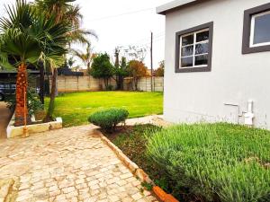 a house with a yard with a palm tree at Ikhayalethu in Centurion