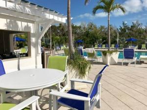 a patio with a table and chairs and a pool at Toes in the Sand - 2 Bedroom Condo Sleeps 4 in Tavernier