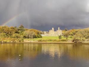 a rainbow over a castle and a lake with a building at B&B At Forty Three in Vatsker