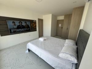 a bedroom with a bed and a tv on the wall at Habitación en casa compartida - No fumadores in Manta