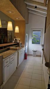 a large kitchen with white cabinets and a window at Alto Chacras Cottage in Chacras de Coria