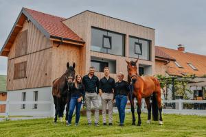 a group of people with horses in front of a house at Hotel Frost in Maribor