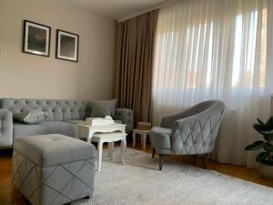 a living room with a couch and chairs and a table at Urban Apartman-privatan parking- in Kraljevo