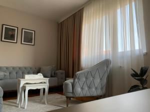 a living room with a couch and a table at Urban Apartman-privatan parking- in Kraljevo