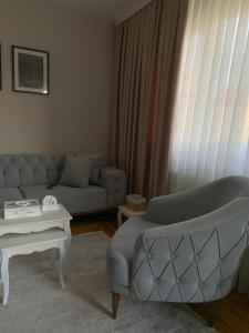 a living room with a couch and a table at Urban Apartman-privatan parking- in Kraljevo