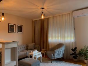 a living room with a couch and a chair at Urban Apartman-privatan parking- in Kraljevo
