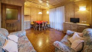 een woonkamer met een bank en een tafel bij Villa Chiappuzza - Stayincortina in San Vito di Cadore