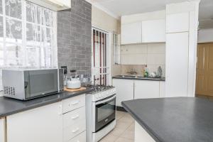 a kitchen with a microwave and a stove top oven at Ikhayalethu in Centurion