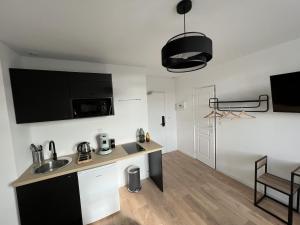 a kitchen and living room with a sink and a table at Le Cosy, 2P Centre-ville in Liévin