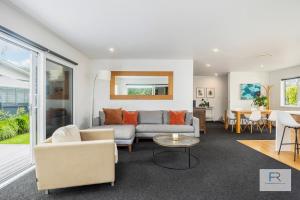 a living room with a couch and a table at Stylish Northcote Point Bungalow in Auckland +10 photos