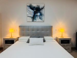 a bedroom with a large white bed with two lamps at Loft muy céntrico a 250m del mar in Vinarós