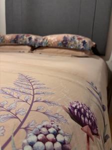 a bed with a blanket with flowers on it at The Barn, Walworth Demesne in Ballykelly