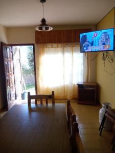 a living room with a flat screen tv on the wall at Chalet Santa Teresita in Santa Teresita