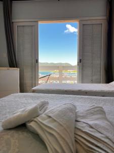 una camera con letto e vista sulla spiaggia di Pousada Casa da Praia ad Arraial do Cabo