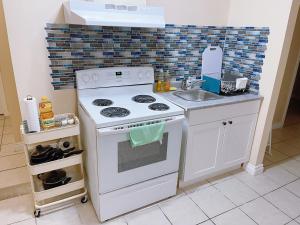 a kitchen with a white stove and a sink at UofC-SAIT-Banff Trail-Suite A&B in Calgary