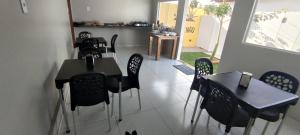 a dining room with black tables and chairs and a window at Pousada Santo Rio in Piranhas +77 photos