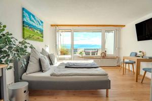 ein Schlafzimmer mit einem Bett und einem großen Fenster in der Unterkunft Ferienwohnung BergWolke mit Pool & Sauna in Scheidegg