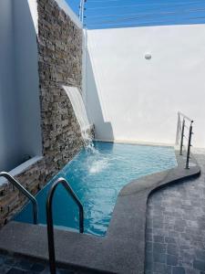 una piscina en un edificio con una fuente de agua en Casa hermosa con piscina, en Salinas