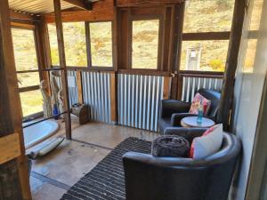 a living room with two chairs and a table at Romantic Cottage in Barrydale