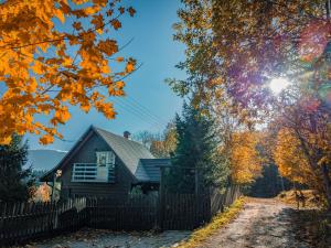 a house on a road next to a fence at Alemiło - uroczy dom z balią i widokiem na Babią Górę in Zawoja