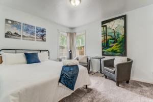 ein Schlafzimmer mit einem großen Bett und zwei Stühlen in der Unterkunft Steps to Downtown Eateries & Bars - With Fire Pit! in Colorado Springs