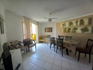 uma sala de estar com mesa e cadeiras em Quarto para temporada na praia do corsário em Salvador