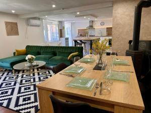 a dining room with a table and a green couch at Appartement moderne in Bussières-lès-Belmont