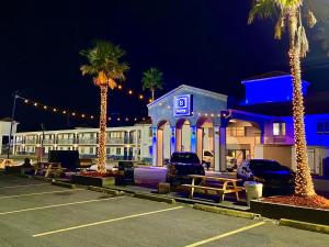 een parkeerplaats met palmbomen voor een gebouw bij Boardwalk Suites Lafayette in Lafayette