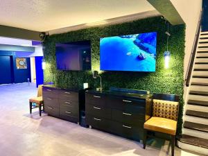 een kamer met een dressoir met een tv aan de muur bij Boardwalk Suites Lafayette in Lafayette