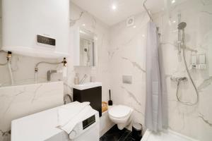a white bathroom with a toilet and a shower at Le Cosy de Saint Epvre - Studio - 2 Pers in Nancy