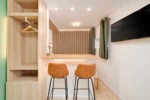 a dressing room with two chairs and a tv at Le Cosy de Saint Epvre - Studio - 2 Pers in Nancy +22 photos