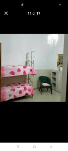 a bedroom with a pink bed and a green chair at Suit catania1946 in Catania