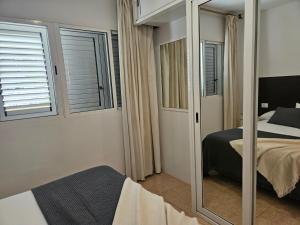 lustro w sypialni z łóżkiem i łóżkiem w obiekcie Flipper Top Suites w mieście San Agustin +7 zdjęć