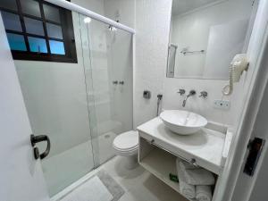 a white bathroom with a sink and a shower at Roame Hosting Boutique in Campos do Jordão +77 photos