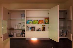 a cupboard with food items in it in a kitchen at GottwaldHaus-Freiberg-Apartment C in Freiberg