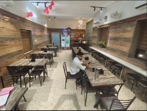 Un uomo seduto a un tavolo in un ristorante di Hotel Hare Krishna Dham a Vrindāvan