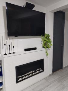a living room with a tv above a fireplace at Semi-loft Manizales Colombia in Manizales