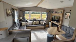 a living room with a couch and a table at Wildcat Lodge Grantown on Spey in Grantown on Spey
