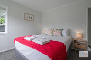 オークランドにあるCosy Bayswater Houseのベッドとタオル2枚のある寝室 +6枚の写真