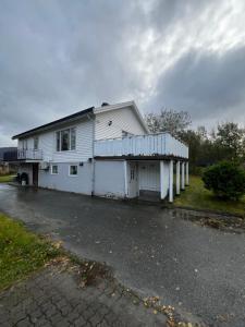 a white house with a balcony on the side of it at Hoda Apartment - Cozy central apartment with free parking in Leknes