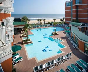 an overhead view of a pool with chairs and the beach at Holiday Inn & Suites Virginia Beach - North Beach by IHG in Virginia Beach