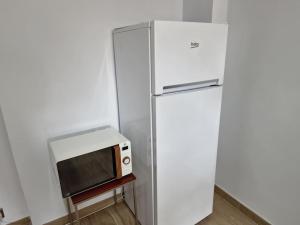 a white refrigerator with a microwave on top of it at Gibraltar Sun Poolside Escape in Gibraltar
